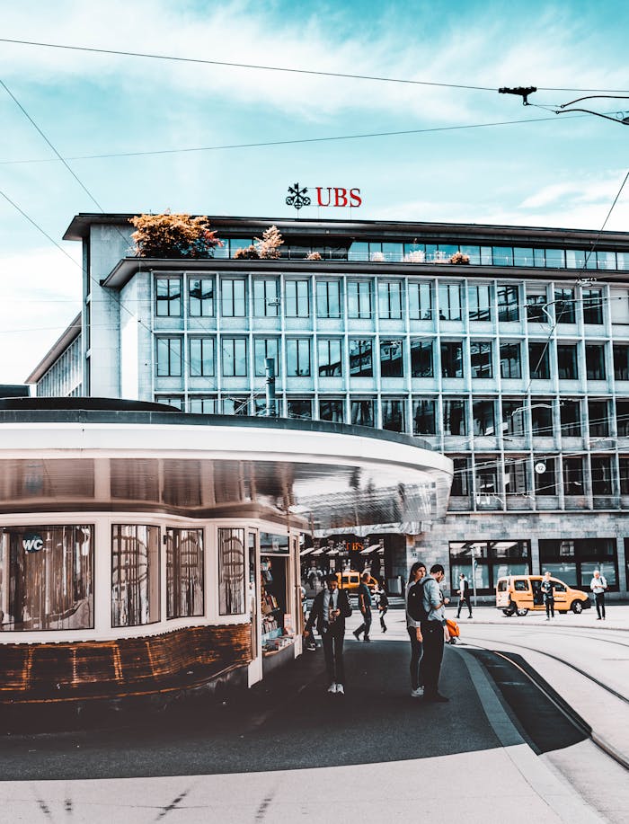 service-06 Street scene in Zürich showcasing tramways, buildings, and people under a blue sky.
