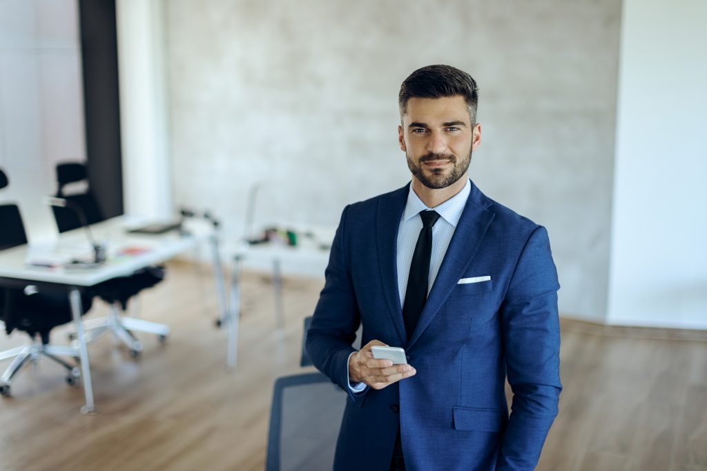 young businessman using mobile phone in the office and looking a young businessman using mobile phone in the office and looking a